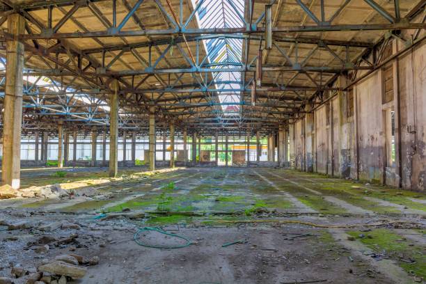 istock Abandoned large factory industrial interior. 1065742984