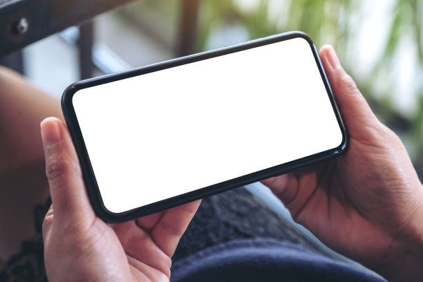 istock Mockup image of woman's hands holding and using a black mobile phone with blank screen horizontally for watching 1065752518