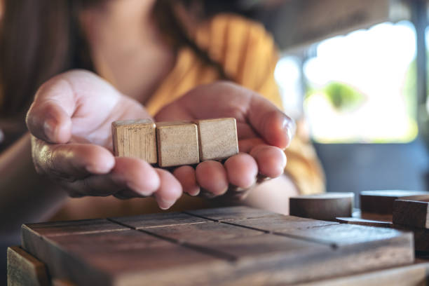 istock Woman's hands holding and showing three square wooden blocks 1065754904