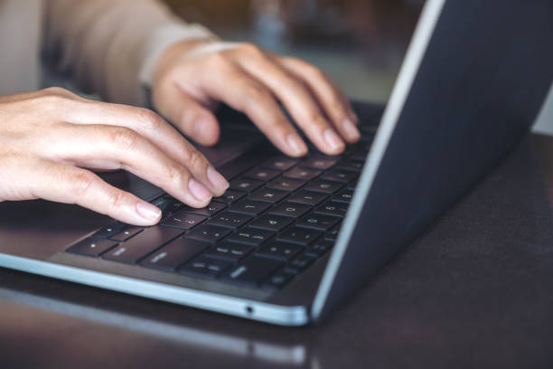 istock Closeup image of hands using and typing on laptop keyboard on table 1065756484