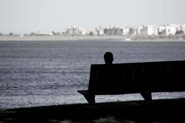 istock silhouette of a man, bench and tree 1065760472