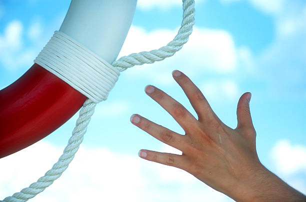 istock A hand reaching for a red and white buoy against blue sky 106576222