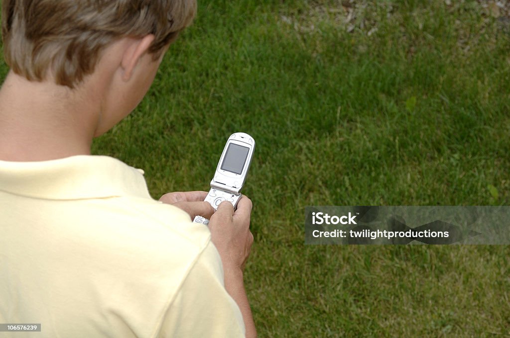 Chłopiec wysyłania wiadomości tekstowych z telefonu komórkowego - Zbiór zdjęć royalty-free (Adolescencja)