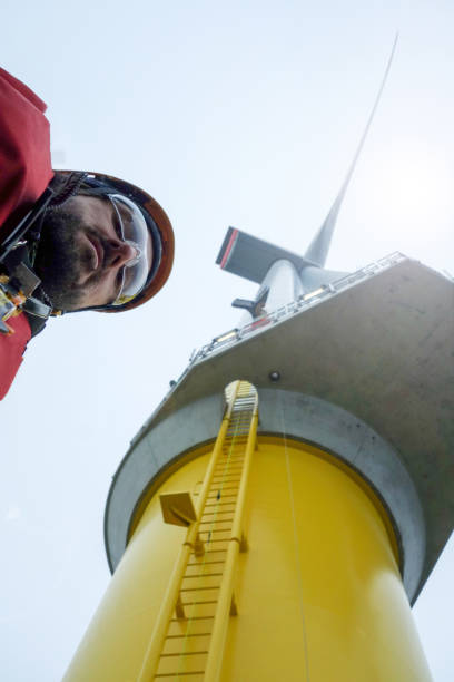 istock Young man technician worker took selfie with gigantic offshore wind-turbine 1065764556
