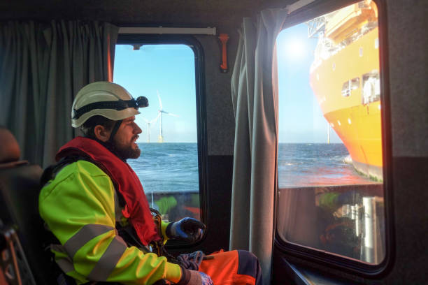 istock Offshore manual worker sitting in transfer vessel by window and looking out 1065764680