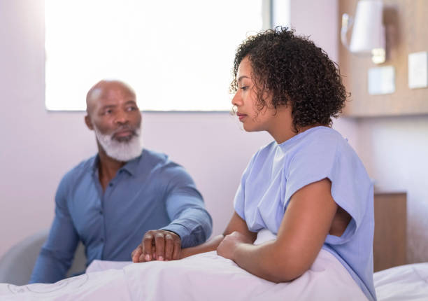 istock Mature father consoling ill daughter by holding hands 1065767282