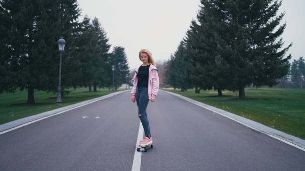 istock Pretty beautiful blond hipster woman with skateboard longboard 1065772040