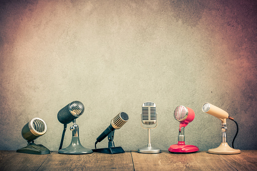 Retro old microphones for press conference or interview on wooden desk. Vintage instagram style filtered photo