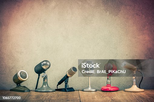 istock Retro old microphones for press conference or interview on wooden desk. Vintage instagram style filtered photo 1065772700