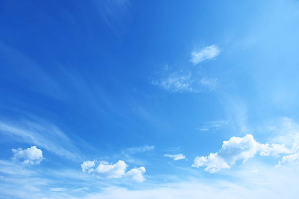 blauer himmel mit vereinzelt wolken - blau stock-fotos und bilder
