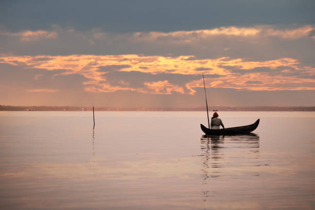 kerala fisherman watching sunset - moody sky water sport passenger craft scenics imagens e fotografias de stock
