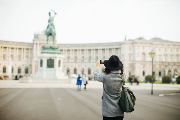 Rear view of woman photographing monument at Heldenplatz in Vienna