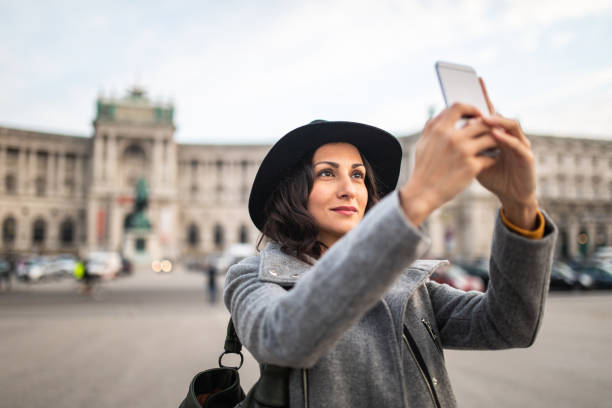Beautiful stylish woman taking photos in Vienna Tourist woman taking selfies in front of public building in Vienna,Austria heldenplatz stock pictures, royalty-free photos & images