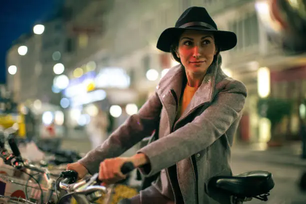 Beautiful woman standing in the street of Vienna and holding citybike