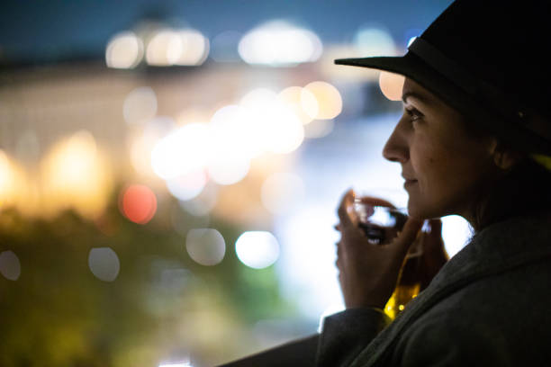 Woman drinking tea and looking at view from the rooftop