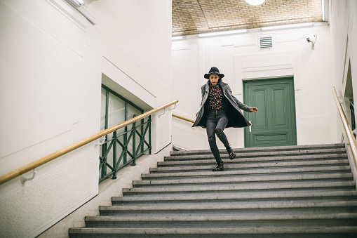 Young woman in a hurry at subway station going down the stairs