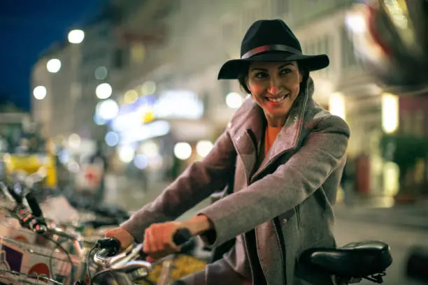 Beautiful woman standing in the street of Vienna and holding citybike