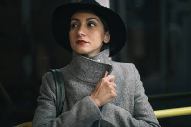 Young beauty woman with hat driving at night in the bus, standing