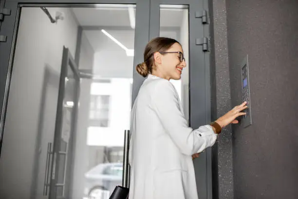 Photo of Woman entering code on the building entrance