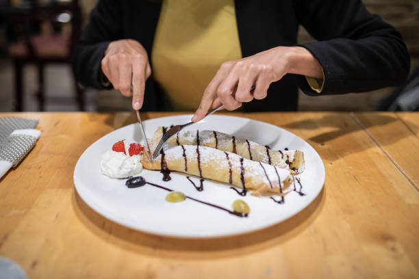 Close up of human hands cutting delicious pancakes