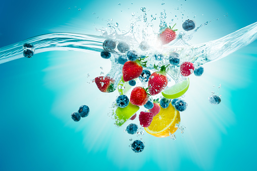 A selection of fruit plunge into water creating a splash