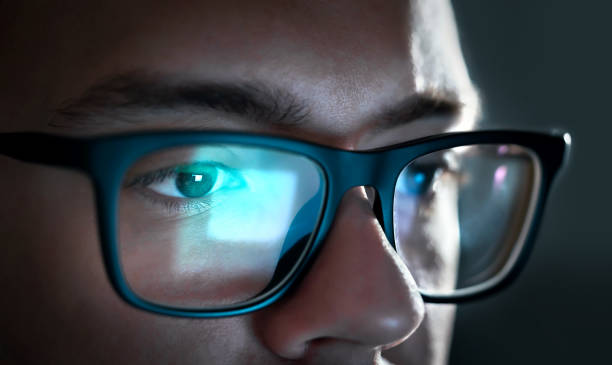 Computer screen light reflect from glasses. Close up of eyes. Business man, coder or programmer working late at night with laptop. Thoughtful focused guy in dark. Computer screen light reflect from glasses. Close up of eyes. Business man, coder or programmer working late at night with laptop. Thoughtful focused guy in dark. Reflection of monitor. eye reflection stock pictures, royalty-free photos & images