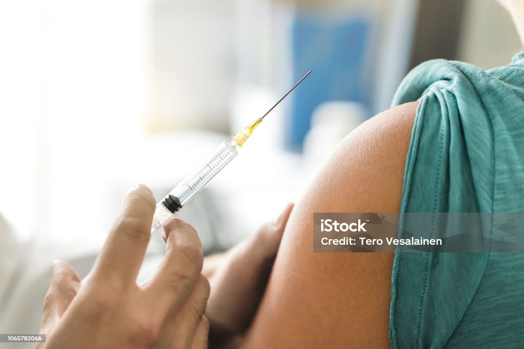 Vacuna contra la gripe o resfriado a tiros en la aguja de inyección. Médico trabaja con el brazo del paciente. Médico o enfermera dando inmunidad y vacunación a virus, influenza y VPH con jeringa. - Foto de stock de Vacunación libre de derechos