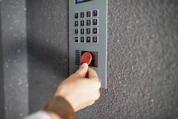 Close-up of intercome keyboard of residential building with keychain opening the door