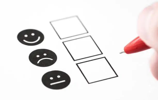 Photo of Customer experience survey, employee feedback questionnaire or business poll concept. Happy smile, neutral and sad frown faces on paper.