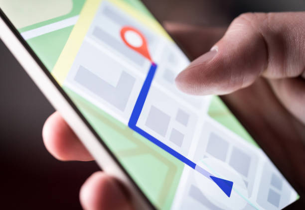 carte d’application dans le smartphone. homme naviguant dans la ville avec téléphone portable. personne à l’aide de téléphone portable et la recherche d’hôtel avec l’appli de navigation. - système gps photos et images de collection