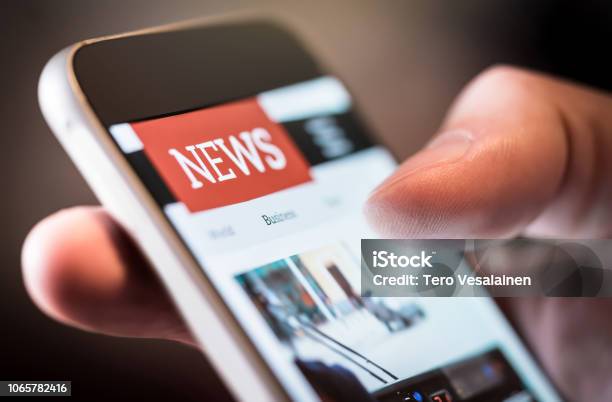 Online News In Mobile Phone Close Up Of Smartphone Screen Man Reading Articles In Application Hand Holding Smart Device Mockup Website Stock Photo - Download Image Now