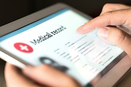 Registro médico electrónico con los datos del paciente y la información sanitaria en tableta. Médico con dispositivo digital inteligente para leer el informe en línea. photo