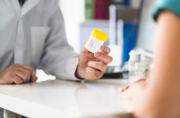 médico, paciente y la orina prueba de la copa. médico entrega contenedor pee a una mujer en la sala de urgencias de clínica u hospital. muestra urinaria para examen médico en el hospital. - orina fotografías e imágenes de stock