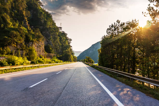 istock Road in the mountain forest in Alps and sunshine 1065787930