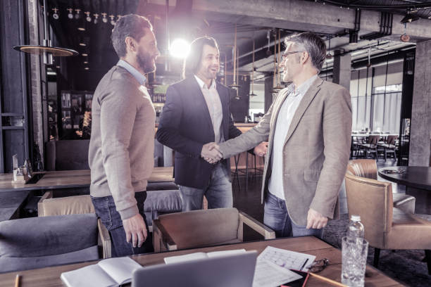 istock Cheerful young males shaking their hands during talk 1065789654