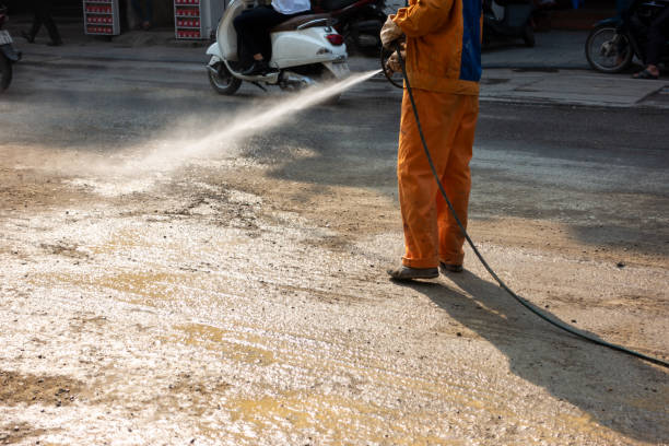 istock Worker making street wet with water spray at construction area 1065789972