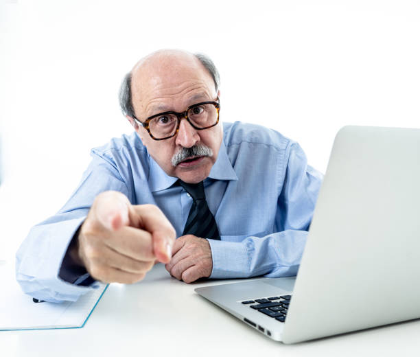 60 anos empresário sênior chefe gritos furiosos e gesticulando chateado e com raiva na mesa em gerenciando e problemas de stress no trabalho isolado no fundo branco. - threats rudeness occupation working - fotografias e filmes do acervo