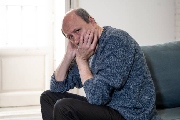 istock Overwhelmed old senior man suffering alone at home feeling confused sad alone on couch at home in Aging Retirement widower Dementia and Alzheimer concept. 1065803692