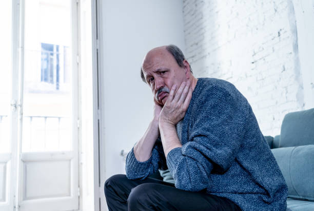 istock Overwhelmed old senior man suffering alone at home feeling confused sad alone on couch at home in Aging Retirement widower Dementia and Alzheimer concept. 1065803878
