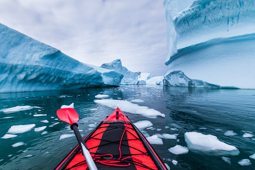 Kayak en la Antártica entre icebergs con kayak inflable, aventura extrema en la Península Antártica, hermoso paisaje prístino, actividad infantil la agua de mar photo