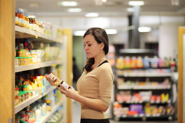 frauen, die sich für ein milchprodukt im supermarkt entscheiden. produktinformationen lesen - food supplement stock-fotos und bilder