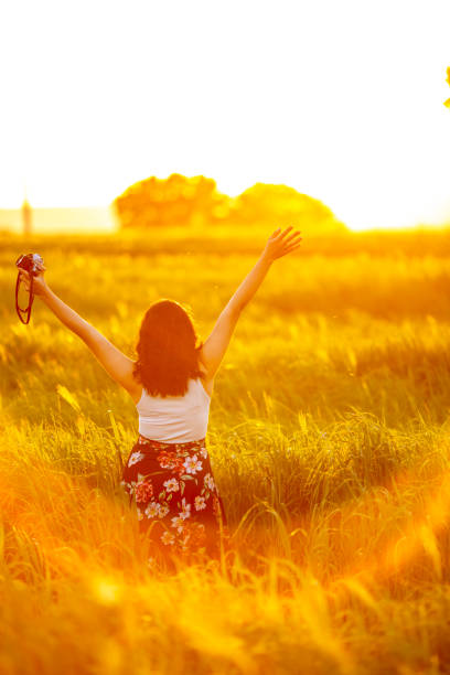 Portrait of a woman with long blonde hair with sun setting in the background