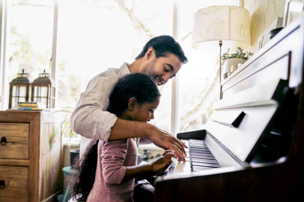 father teaching daughter to play piano - practicing piano child playing imagens e fotografias de stock