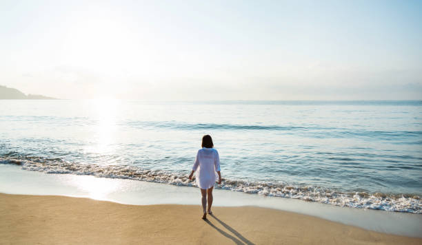istock Young woman standing on beach 1065817060