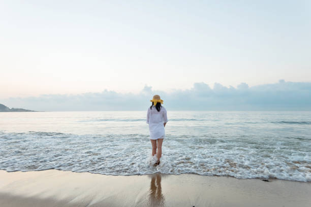 istock Young woman standing on beach 1065817072