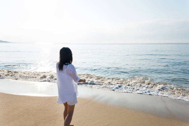 istock Young woman standing on beach 1065817108