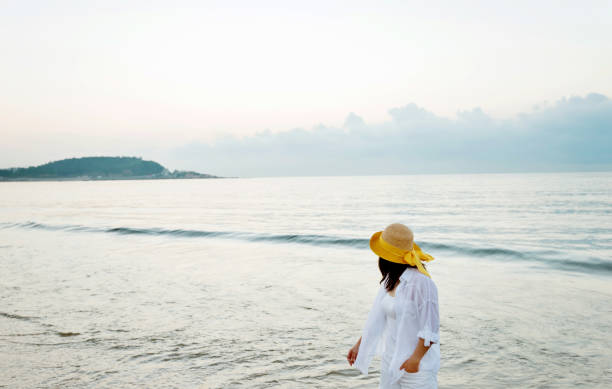 istock Young woman standing on beach 1065817208