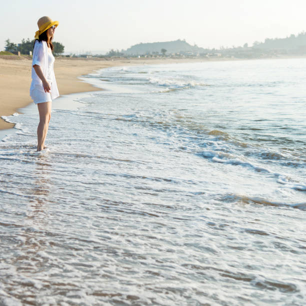 istock Young woman standing on beach 1065817386