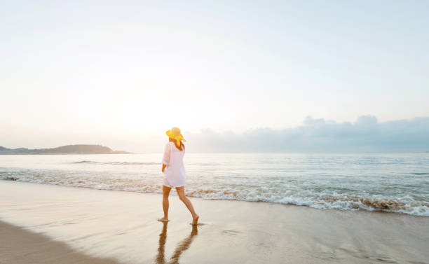 istock Woman walking on the beach 1065817396