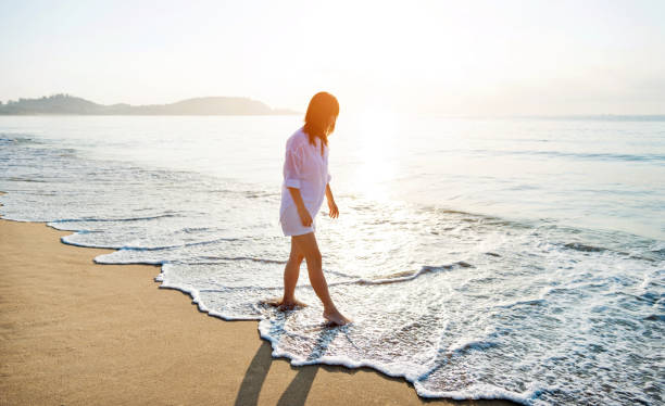 istock Woman walking on the beach 1065818610